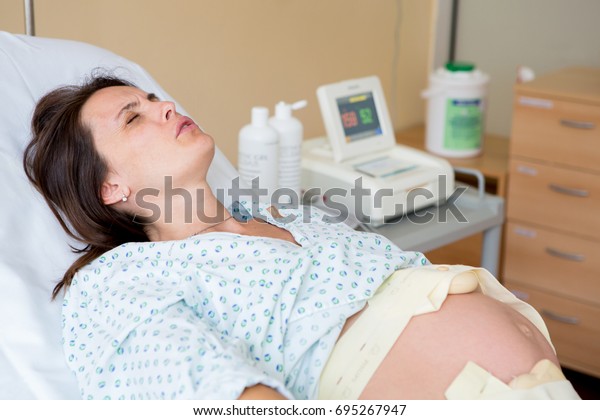 Pregnant\
woman in delivery room, having\
contractions