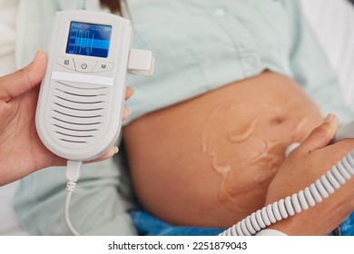 Pregnant woman, doctor hands and heart rate monitor for baby healthcare, medical support or hospital gynecology. Pregnancy maternity consultation, patient stomach and gynecologist with fetal doppler - Powered by Shutterstock