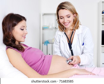 Pregnant woman with doctor in hospital - indoors