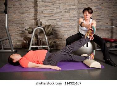 A pregnant woman doing exercises with her personal trainer