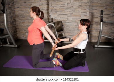 A pregnant woman doing exercises with her personal trainer