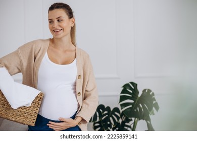 Pregnant Woman Doing Laundry At Home