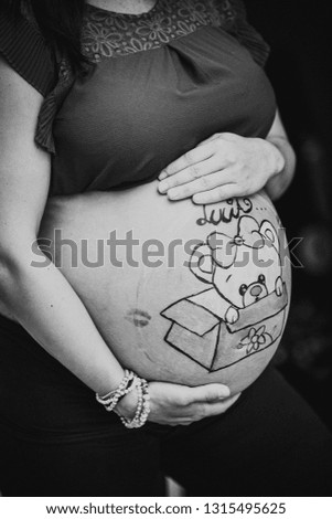a pregnant woman with a drawing painted on her belly