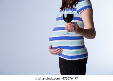Pregnant woman drinking, causing harm to her unborn fetus, by giving it fetal alcohol syndrome.