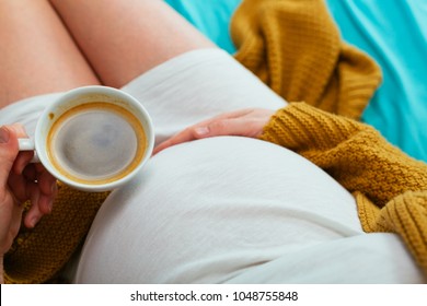 Pregnant Woman Drinking Coffee. Aerial Close Up View.