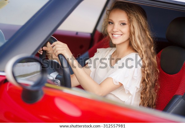 Pregnant Woman Driving a\
Car. pregnant woman in driving seat of the car. portrait of young\
beautiful pregnant woman outdoors. smiling pregnant woman sitting\
in car