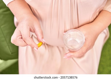 Pregnant Woman Eat Pregnancy Pills. Flu Supplements. Taking Allergy Drugs. Medical Fish Omega 3 Food. People Body. Drink Water. Mother Hand. Sick Female Person At Home. Daily Tablet Container