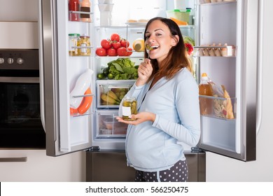 Pregnant Woman Eating Pickle - Powered by Shutterstock