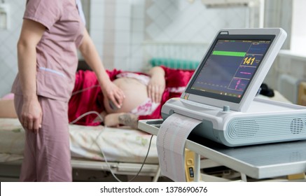 Pregnant woman with electrocardiograph check up for her baby. Fetal heart monitoring. Diagnostic, healthcare, medical service