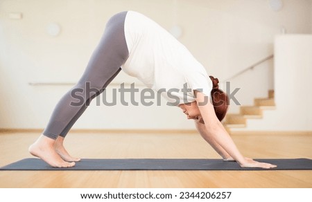Pregnant woman is engaged in yoga. Downward