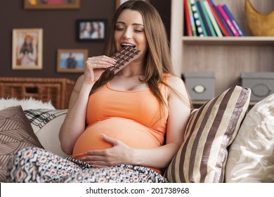 Pregnant woman enjoying of eating chocolate - Powered by Shutterstock