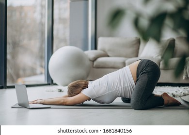 Pregnant woman exercing yoga at home