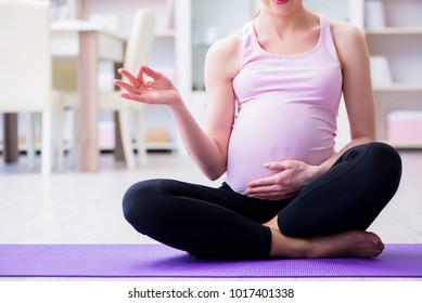 Pregnant Woman Exercising In Anticipation Of Child Birth