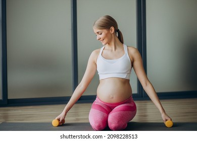 Pregnant Woman Exercising With Dumbells At Home