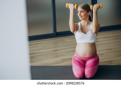 Pregnant Woman Exercising With Dumbells At Home