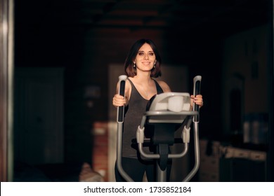 Pregnant Woman Exercising On Elliptical Machine At Home. Mother To Be Training On Fitness Apparatus
