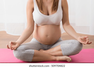 Pregnant Woman Exercising Yoga In Antenatal Class