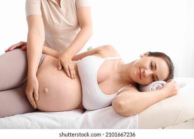 Pregnant woman getting massage by therapist in spa salon - Powered by Shutterstock