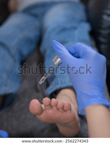 Pregnant woman getting a pedicure in a beauty salon. The technician applies moisturizing oil to the client's feet. 