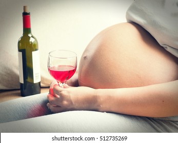 Pregnant woman with glass of wine in hand. Concept of Pregnancy health care.