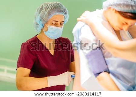 Pregnant woman has a peridural anesthesia by child birth. Epidural anesthesia injections. Prepare for surgery. Medical background.