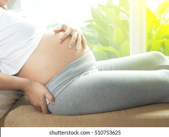 Pregnant woman having back aches in the last trimester of pregnancy. Concept of pregnancy health care.