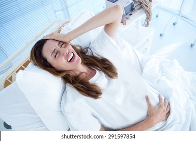 Pregnant woman having birth pangs in hospital room - Powered by Shutterstock