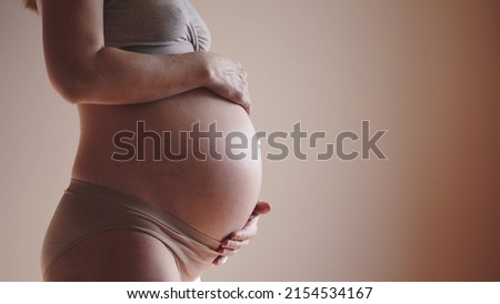 pregnant woman. health pregnancy sunlight motherhood procreation concept. close-up belly of a pregnant woman. woman waiting for a newborn baby. pregnant woman holding her belly indoors