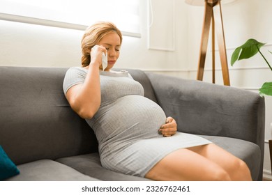 Pregnant woman in her 30s feeling sad and emotional while crying alone at home - Powered by Shutterstock