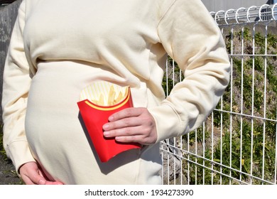 A Pregnant Woman In Her Twenties Has French Fries. Unbalanced Diets During Pregnancy Are Not Good, But Many People Want To Eat French Fries.