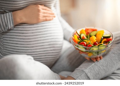 Pregnant Woman Holding Bowl With Fresh Vegetable Salat While Sitting On Bed, Expectant Mother Enjoying Healthy Nutrition During Pregnancy, Choosing Organic Meal, Cropped Image, Closeup - Powered by Shutterstock