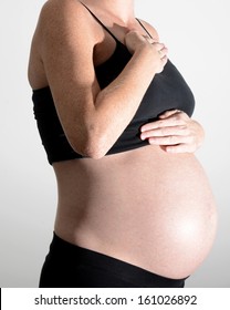 Pregnant Woman Holding Chest And Throat From Heartburn 