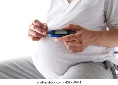 Pregnant Woman Holding Glucose Meter. Gestational Diabetes. 