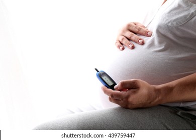 Pregnant Woman Holding Glucose Meter. Gestational Diabetes. 