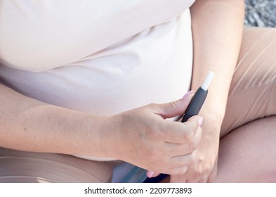 Pregnant Woman Holding In Hand Electronic Cigarette Device.smoke Free Alternative Line Heated Tobacco.no Smoking During Pregnancy,world Anti No Tobacco Day 31st May.advanced Belly Third Last Trimester