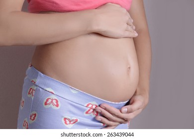 Pregnant Woman Holding Her Belly, Second Trimester