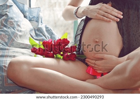 pregnant woman holding her hands on her bare belly