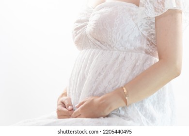 A Pregnant Woman Holding Her Stomach In A Maternity Dress White Background (shooting A Real Pregnant Woman)