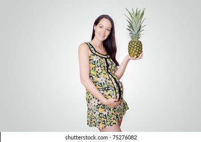 Pregnant Woman Holding Pinapple In Her Hand Studio Shoot Isolated On Grey