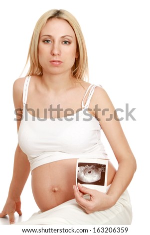 A pregnant woman holding an ultrasound picture of her baby, closeup