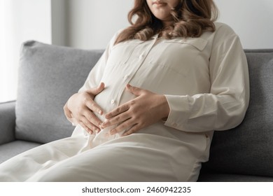 Pregnant woman holds hands on belly touching her baby caring about her health Beautiful happy pregnant woman 
tender mood photo of pregnancy. - Powered by Shutterstock