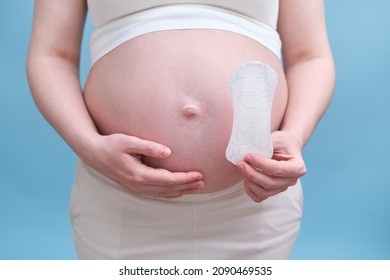 A Pregnant Woman Holds A Sanitary Pad In Her Hands