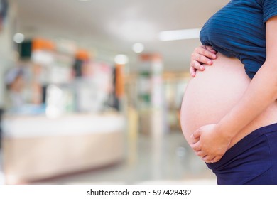 Pregnant woman with hospital blur background - Powered by Shutterstock