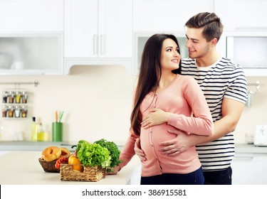 Pregnant woman with husband in the kitchen - Powered by Shutterstock