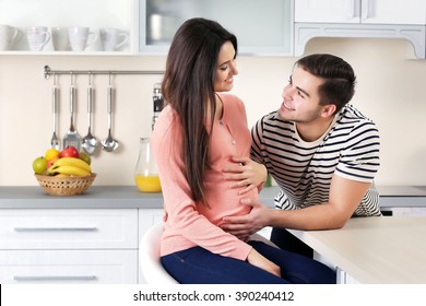 Pregnant woman with husband in the kitchen