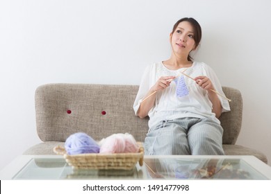 Pregnant Woman Knitting On The Sofa