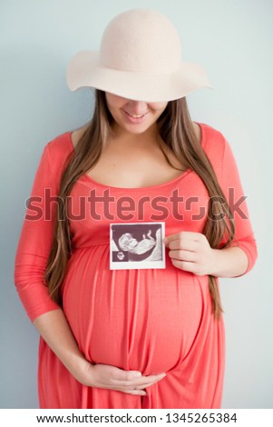 pregnant woman looking at ultrasound scan of baby