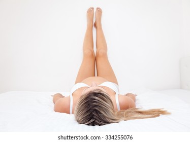 Pregnant Woman Lying On Bed With Legs Raised Up