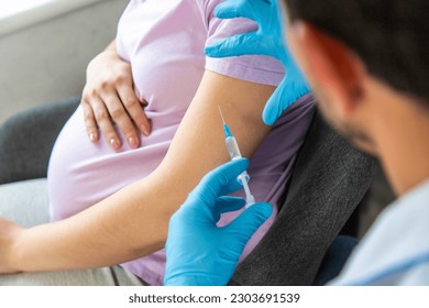 A pregnant woman makes a vaccination. Selective focus. doctor. - Powered by Shutterstock