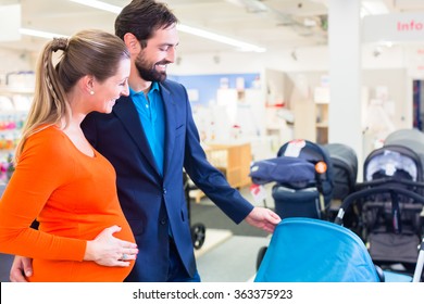 Pregnant Woman And Man In Baby Shop Looking For Stroller To Buy